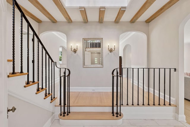 4201 Dupont Ave S, Minneapolis, MN 55409 - staircase featuring beamed ceiling, arched walkways, and baseboards
