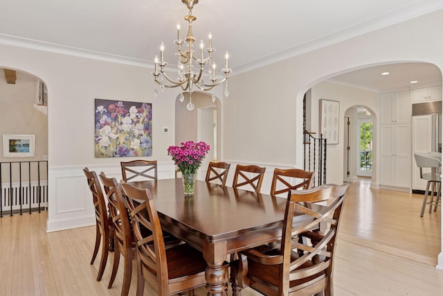 4201 Dupont Ave S, Minneapolis, MN 55409 - dining room with arched walkways, light wood-style floors, crown molding, a chandelier, and stairs