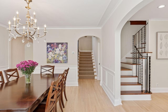 4201 Dupont Ave S, Minneapolis, MN 55409 - dining room with stairs, light wood-style floors, arched walkways, crown molding, and a wainscoted wall