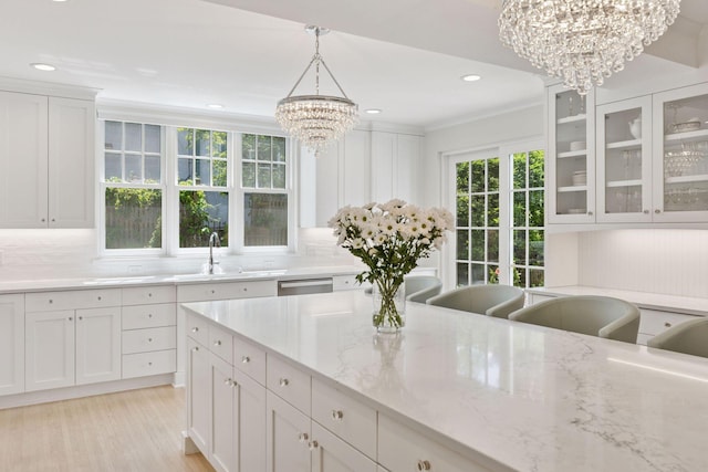 4201 Dupont Ave S, Minneapolis, MN 55409 - kitchen with a chandelier, white cabinetry, ornamental molding, decorative backsplash, and a sink