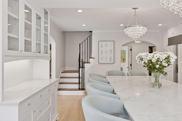 4201 Dupont Ave S, Minneapolis, MN 55409 - dining space with arched walkways, a chandelier, light wood finished floors, recessed lighting, and stairway