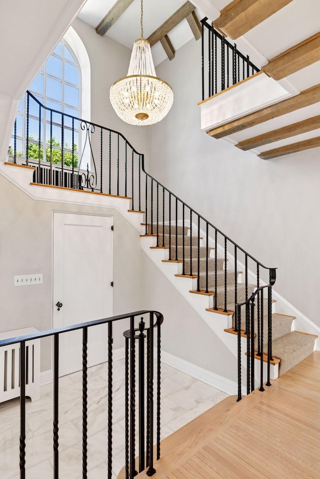 4201 Dupont Ave S, Minneapolis, MN 55409 - stairs with marble finish flooring, a chandelier, a towering ceiling, beamed ceiling, and baseboards