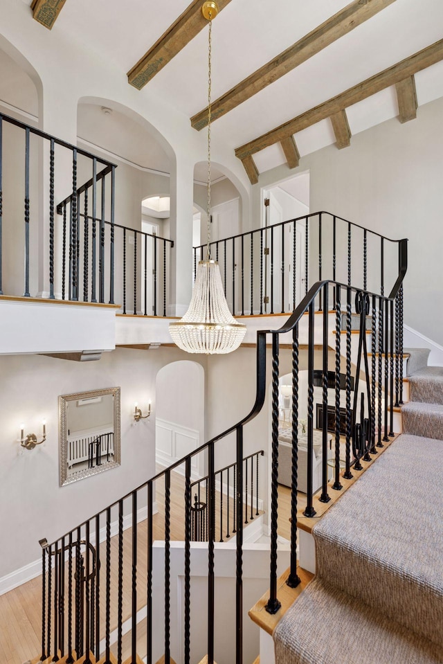 4201 Dupont Ave S, Minneapolis, MN 55409 - staircase with wood finished floors, beam ceiling, baseboards, and arched walkways