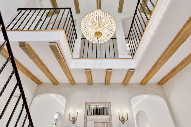 4201 Dupont Ave S, Minneapolis, MN 55409 - stairs featuring beam ceiling, a chandelier, arched walkways, and a high ceiling
