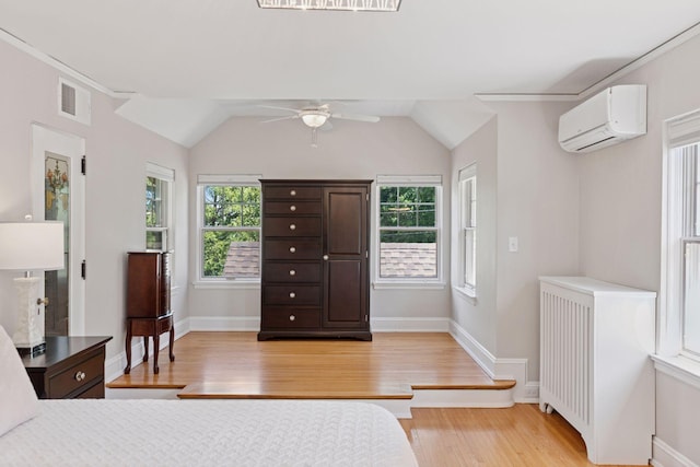 4201 Dupont Ave S, Minneapolis, MN 55409 - bedroom with a wall mounted air conditioner, light wood finished floors, radiator heating unit, baseboards, and lofted ceiling
