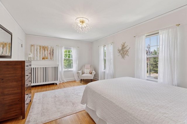 4201 Dupont Ave S, Minneapolis, MN 55409 - bedroom featuring radiator, wood finished floors, crown molding, a chandelier, and baseboards