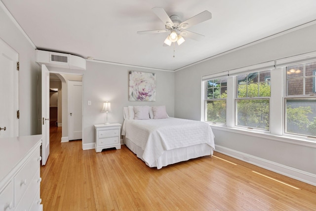 4201 Dupont Ave S, Minneapolis, MN 55409 - bedroom with baseboards, light wood finished floors, arched walkways, and ceiling fan