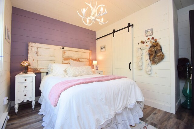 28607 Great Bear Path Way, Danbury, WI 54830 - bedroom featuring wood walls, wood finished floors, a chandelier, a barn door, and a baseboard radiator