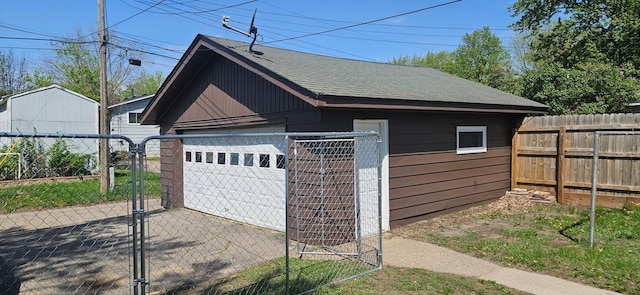 detached garage with fence and a gate