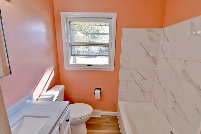 bathroom featuring baseboards, toilet, vanity, and wood finished floors