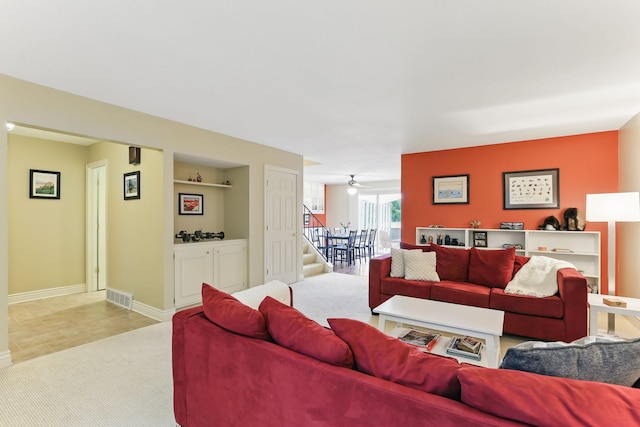 166 Windsor Ln, New Brighton, MN 55112 - living area with stairway, light carpet, baseboards, and a ceiling fan