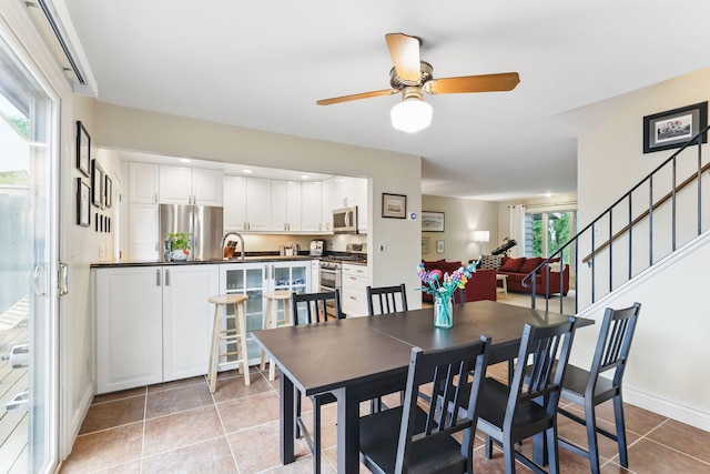 166 Windsor Ln, New Brighton, MN 55112 - dining area with ceiling fan, stairway, light tile patterned flooring, and baseboards