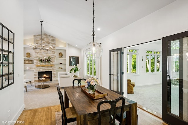820 Vineland Ct, Chanhassen, MN 55317 - dining room featuring light wood-style floors, a fireplace, built in shelves, high vaulted ceiling, and baseboards