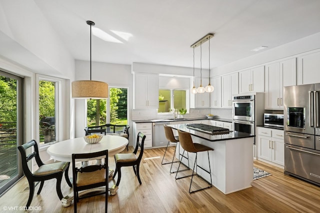 820 Vineland Ct, Chanhassen, MN 55317 - kitchen with stainless steel appliances, decorative backsplash, white cabinetry, a breakfast bar, and a center island