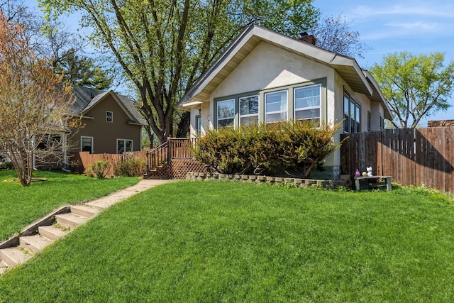 view of front of property featuring stucco siding, a chimney, and a wooden deck