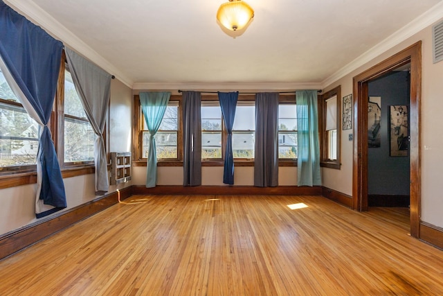 spare room with light wood-style floors, baseboards, and crown molding