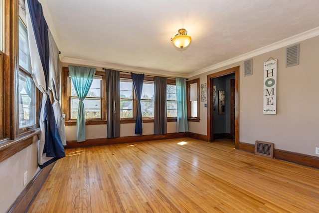 unfurnished room featuring light wood-style flooring, baseboards, and ornamental molding