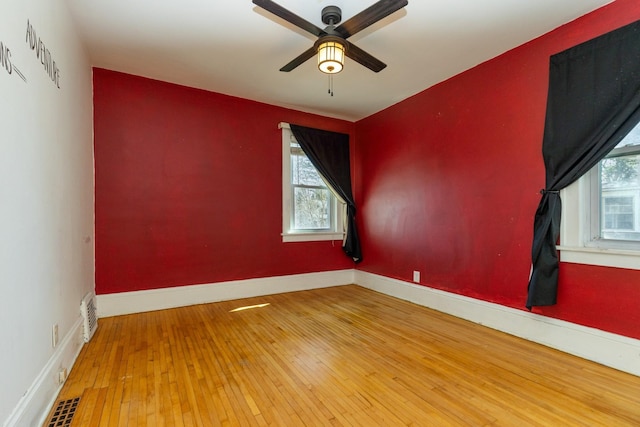 empty room featuring ceiling fan, wood-type flooring, and baseboards