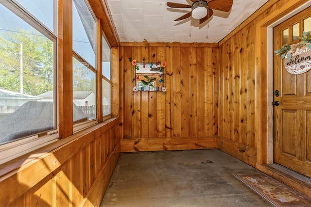 unfurnished sunroom featuring wood walls