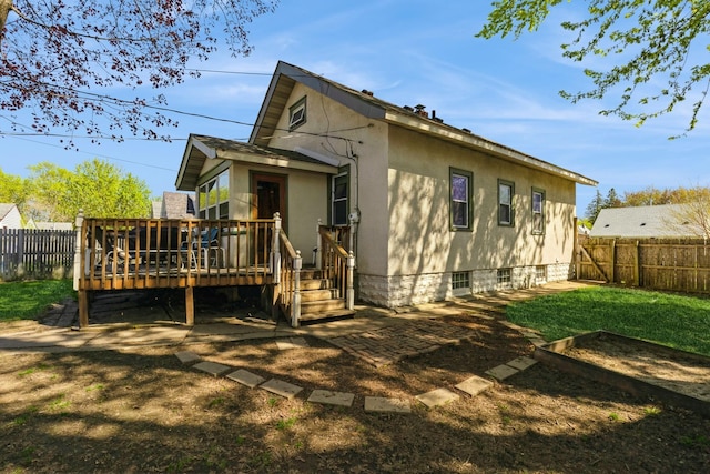 rear view of property featuring a fenced backyard and a wooden deck