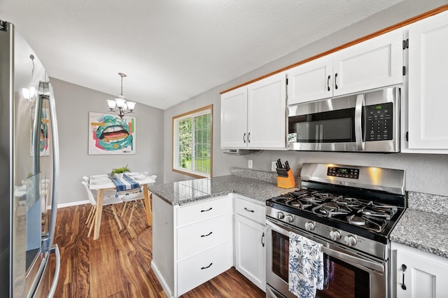 10751 Kumquat St NW, Coon Rapids, MN 55448 - kitchen featuring stainless steel appliances, a peninsula, vaulted ceiling, dark wood-style floors, and white cabinetry