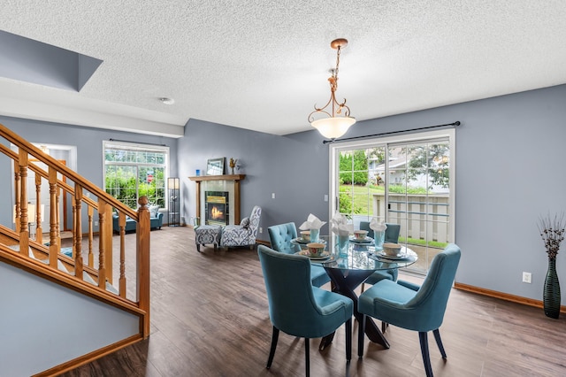 7954 Timber Lake Dr, Eden Prairie, MN 55347 - dining space with plenty of natural light, a textured ceiling, wood finished floors, stairway, and a tiled fireplace