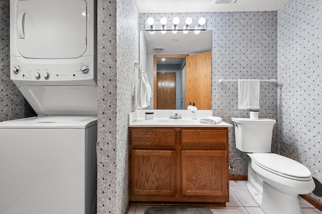 7954 Timber Lake Dr, Eden Prairie, MN 55347 - half bath with stacked washer / drying machine, vanity, tile patterned floors, and wallpapered walls