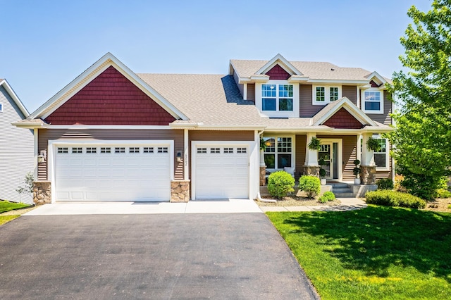 craftsman-style home with asphalt driveway, an attached garage, stone siding, and a front yard