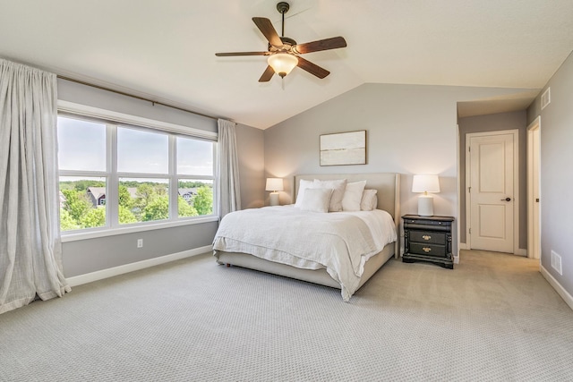 bedroom featuring light colored carpet, vaulted ceiling, baseboards, and a ceiling fan