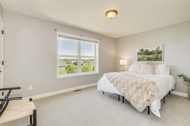 bedroom with baseboards and light colored carpet