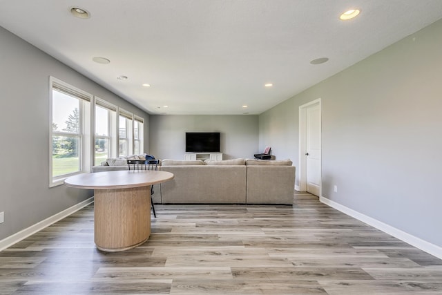 living room with baseboards, light wood-type flooring, and recessed lighting