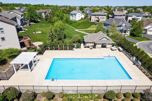 view of swimming pool with fence, a residential view, and a patio