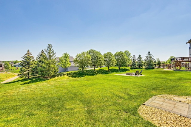 view of grassy yard with an outdoor fire pit