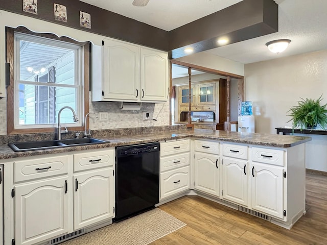 2216 County Road 15, Russell, MN 56169 - kitchen with black dishwasher, a sink, light wood-type flooring, a peninsula, and white cabinetry