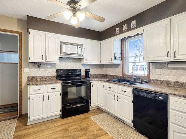 2216 County Road 15, Russell, MN 56169 - kitchen with black appliances, a sink, white cabinets, light wood-type flooring, and tasteful backsplash