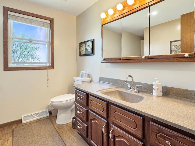 2216 County Road 15, Russell, MN 56169 - bathroom featuring toilet, wood finished floors, vanity, and baseboards