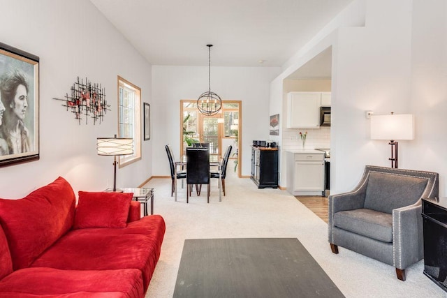living area with a chandelier and light colored carpet
