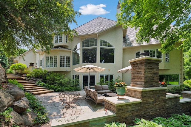 490 Old Long Lake Rd, Orono, MN 55391 - rear view of property featuring stucco siding, a patio area, outdoor lounge area, and a chimney