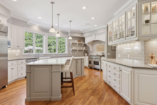 490 Old Long Lake Rd, Orono, MN 55391 - kitchen with built in appliances, decorative backsplash, a breakfast bar area, a sink, and white cabinetry