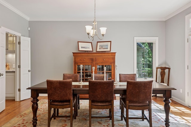 490 Old Long Lake Rd, Orono, MN 55391 - dining space featuring light wood-style flooring, a chandelier, and crown molding