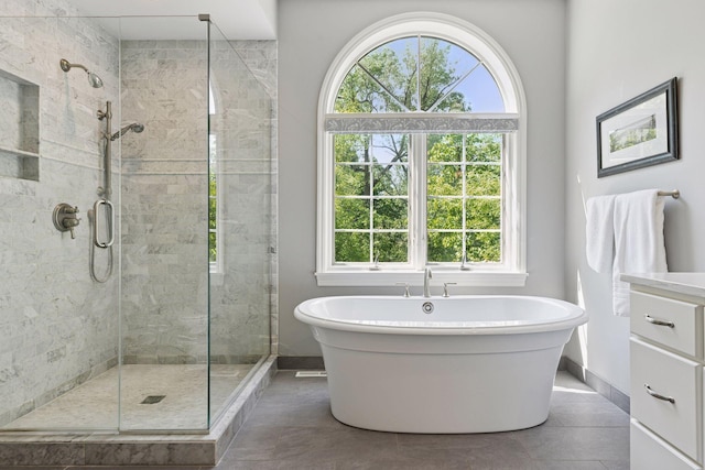 490 Old Long Lake Rd, Orono, MN 55391 - bathroom with a freestanding bath, a stall shower, tile patterned floors, and baseboards
