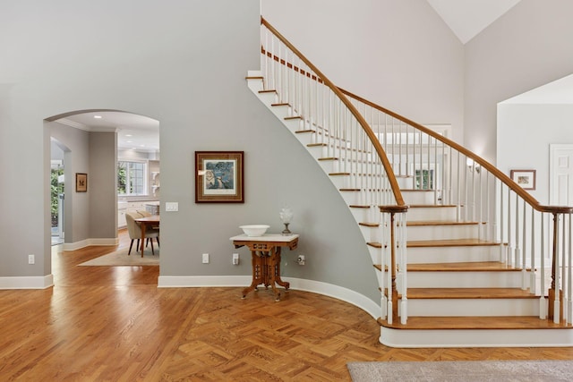 490 Old Long Lake Rd, Orono, MN 55391 - stairway featuring arched walkways, high vaulted ceiling, baseboards, crown molding, and recessed lighting