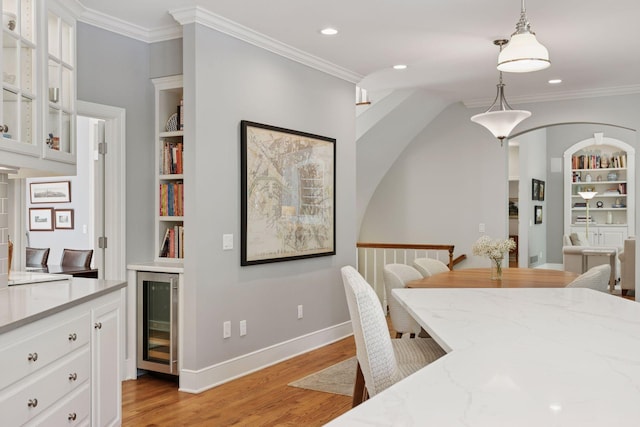 490 Old Long Lake Rd, Orono, MN 55391 - dining area featuring wine cooler, light wood-type flooring, crown molding, built in shelves, and recessed lighting