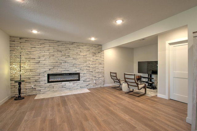 910 Shady Ridge Ln, Braham, MN 55006 - living room featuring a fireplace, wood finished floors, baseboards, a textured ceiling, and recessed lighting
