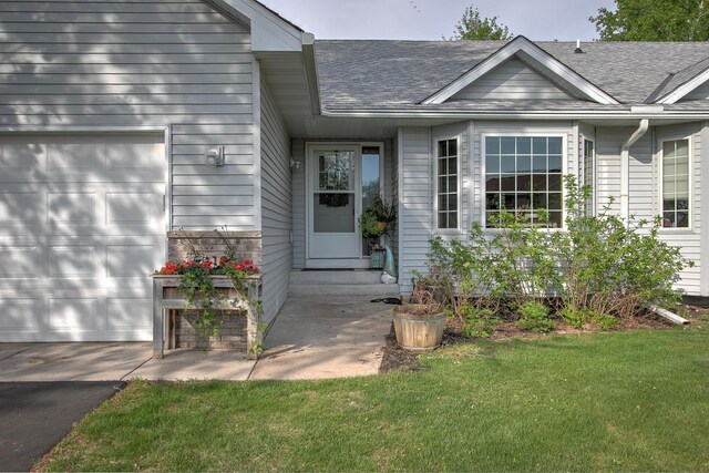 910 Shady Ridge Ln, Braham, MN 55006 - doorway to property featuring an attached garage, a shingled roof, and a lawn