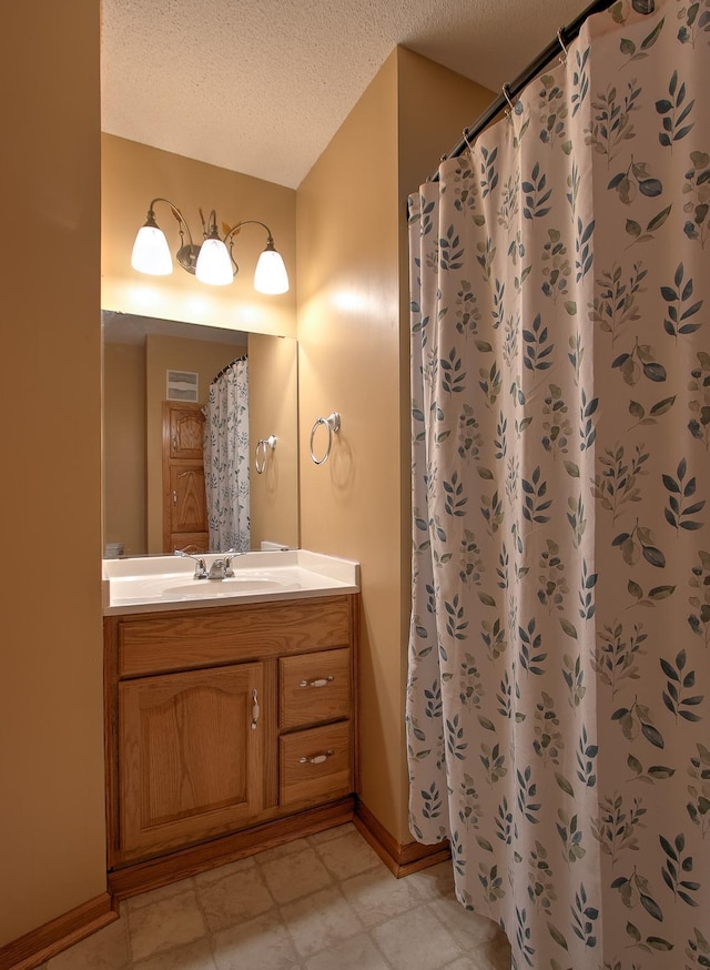 910 Shady Ridge Ln, Braham, MN 55006 - bathroom featuring a textured ceiling, baseboards, vanity, and a shower with shower curtain