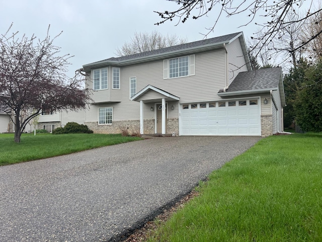 view of front of house featuring driveway, brick siding, a front lawn, and a shingled roof