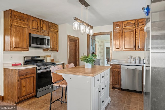 920 2nd St S, Stillwater, MN 55082 - kitchen featuring stainless steel appliances, light countertops, brown cabinets, and a kitchen bar