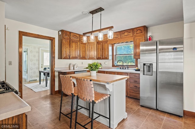 920 2nd St S, Stillwater, MN 55082 - kitchen with stainless steel refrigerator with ice dispenser, brown cabinetry, a breakfast bar area, a center island, and butcher block counters