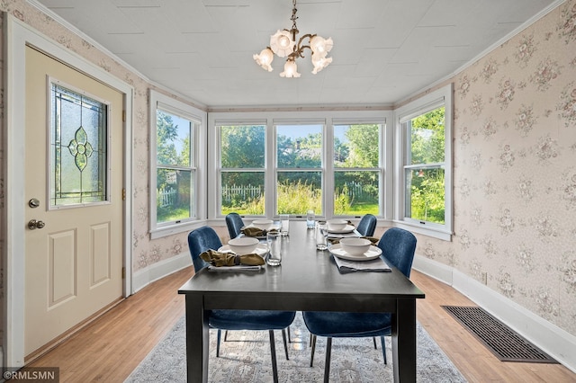 920 2nd St S, Stillwater, MN 55082 - dining room featuring light wood-style floors, a chandelier, wallpapered walls, and crown molding